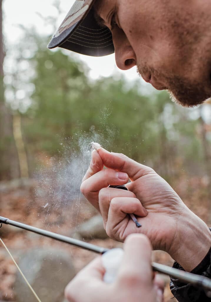 Man blowing on fly fishing bait