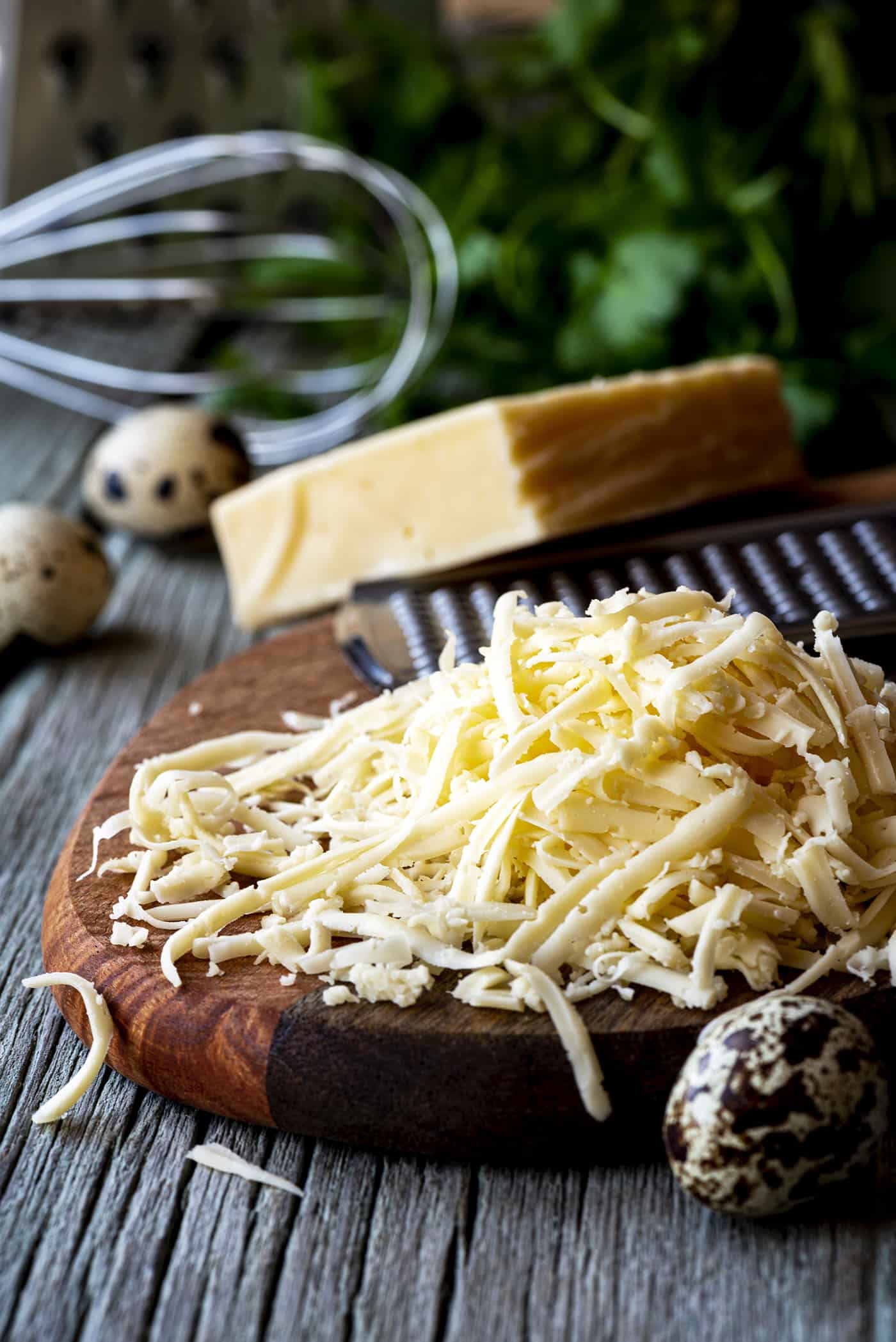 Pile of grated cheese close-up on a wooden cutting board