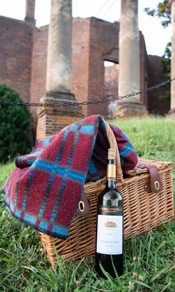 Wine bottle and a picnic hamper and picnic blanket at a Virginia winery. Barboursville Vineyards 2016 Vermentino Reserve.