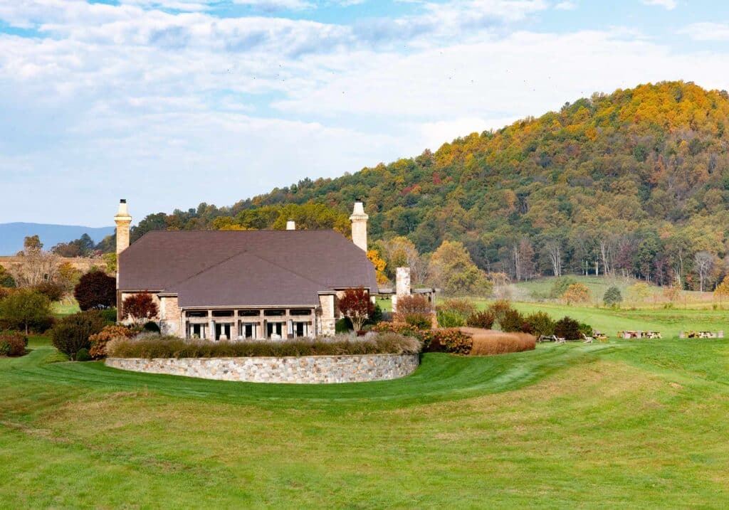 The exterior of Early Mountain Vineyards with fall leaves on tree covered hills.