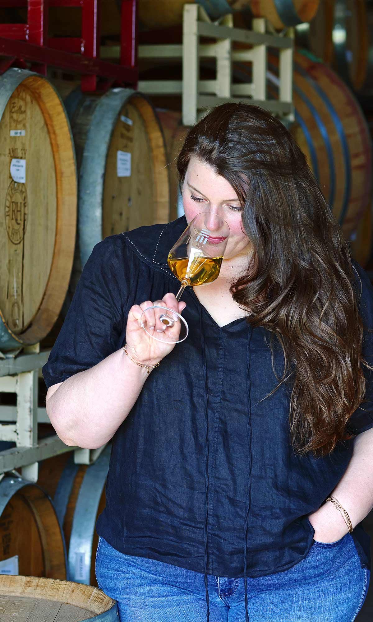 Maya Hood White, winemaker at Early Mountain Vineyards, tasting wine in the barrel room.