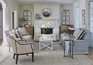 Photo of Casey Sanford designed home with elegant French touches. Round gold mirror above white mantel, collage of nature art