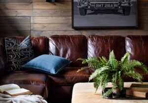 Photo of cozy study with leather sofa and vintage auto art designed by Casey Sanford ofVirginia