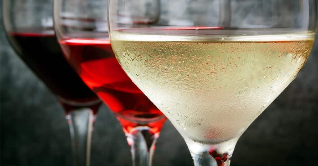 Close-up of 3 wine glasses of red, rosé and white wine