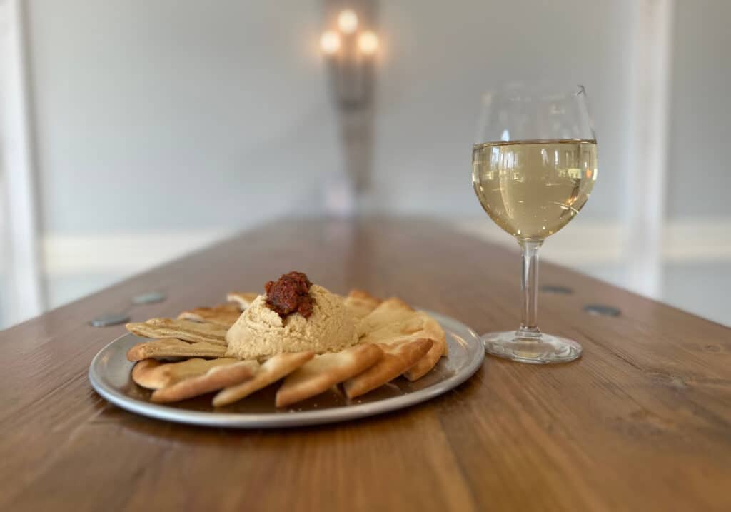 Photo of a plate of appetizer with a glass of wine from Prince Michel Winery